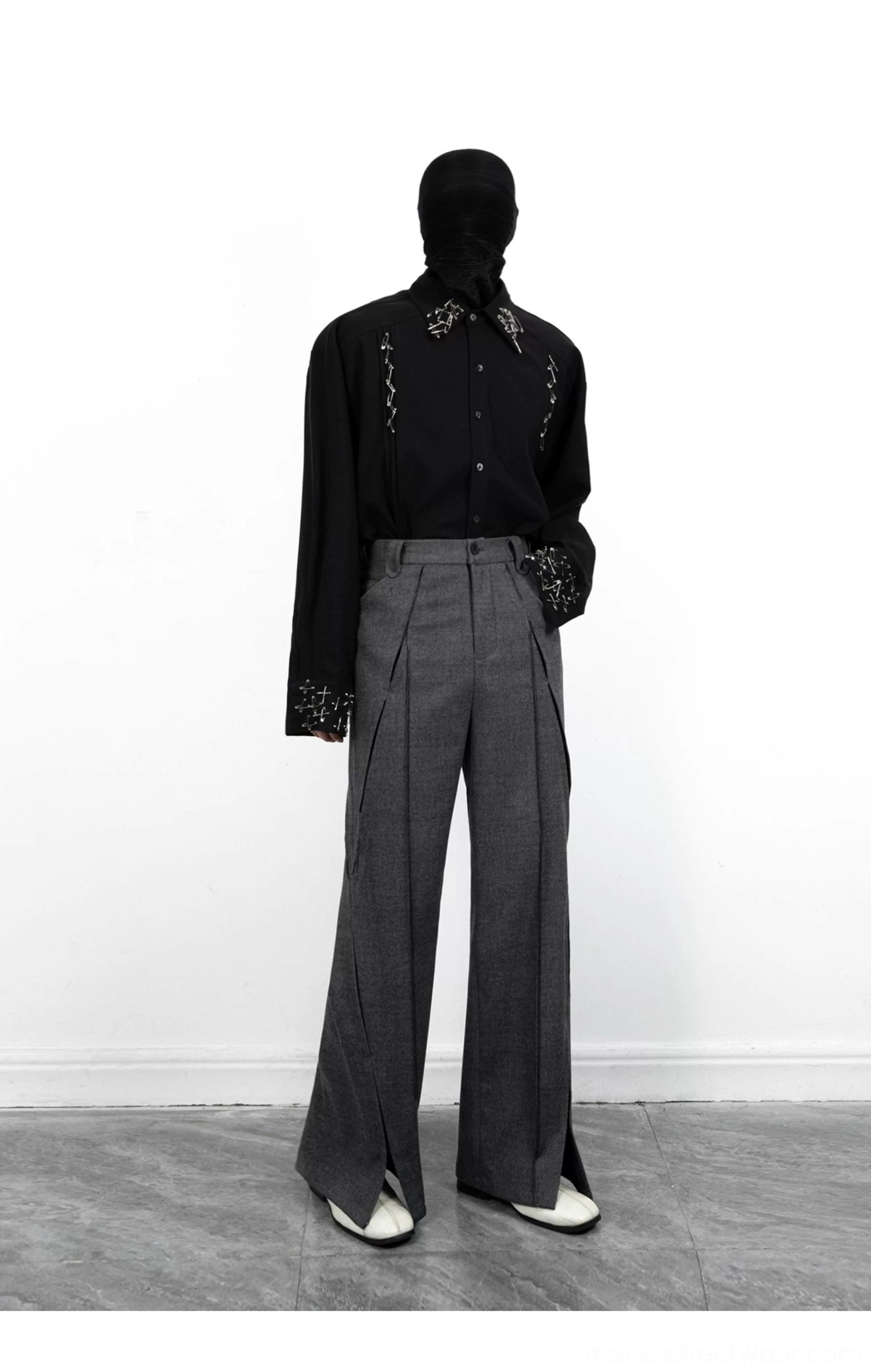 Front mannequin view of dark grey high-waisted split-hem trousers with vertical pleats and a wide structured leg