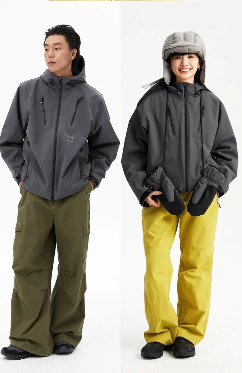 Dark grey hooded outdoor jackets styled on male and female models with a relaxed fit and functional chest pockets