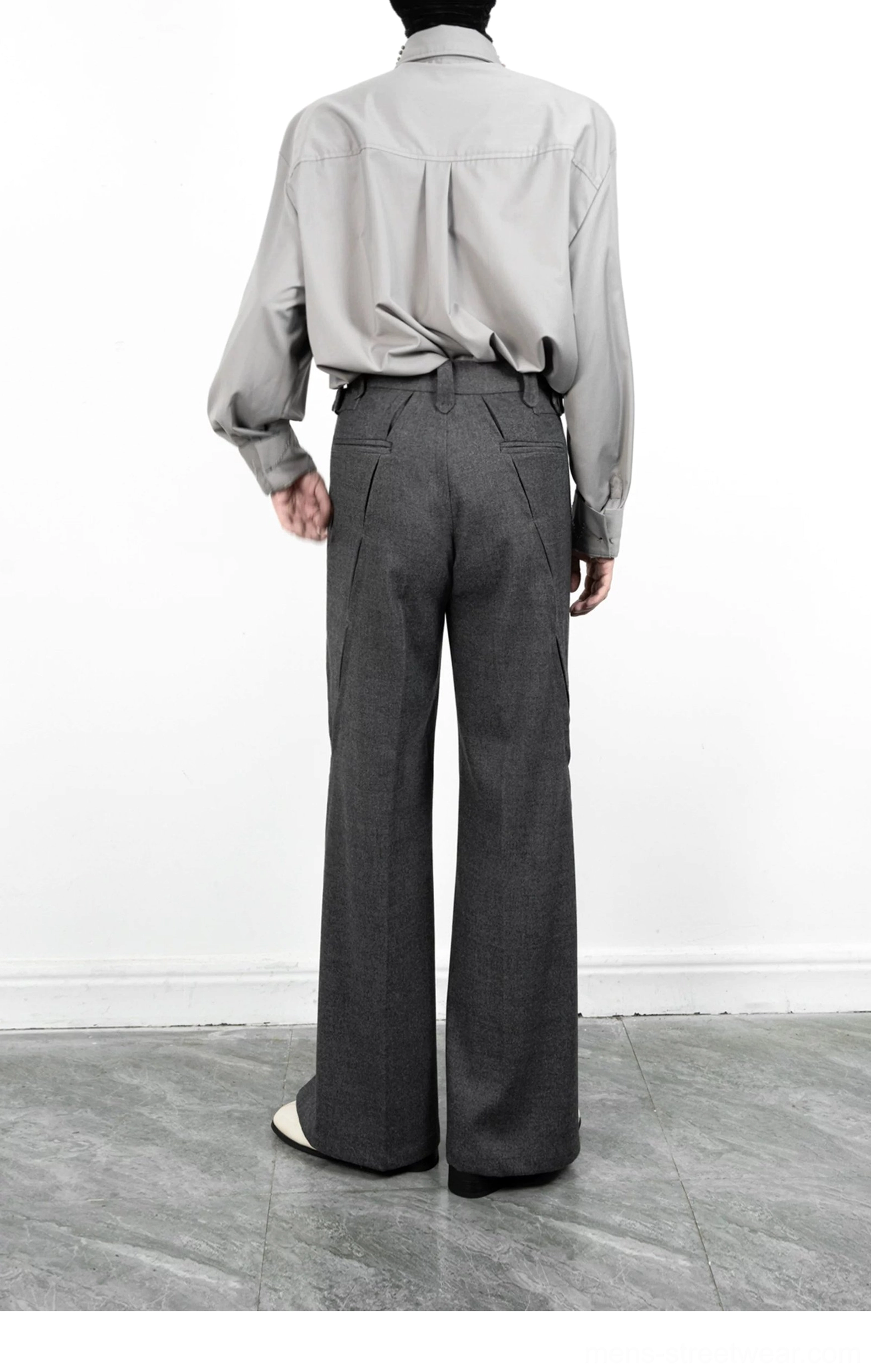 Back view of dark grey wide-leg tailored trousers with belt loops, welt pockets, smooth suiting fabric, and split hems