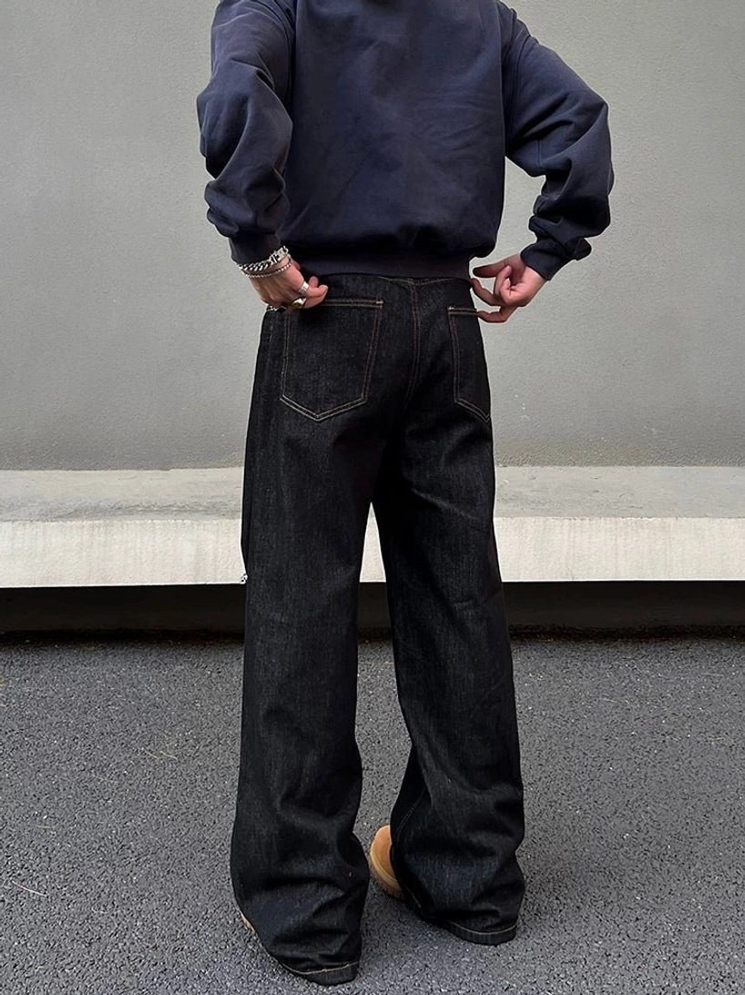 Rear full-body view of dark indigo wide leg jeans showing classic back patch pockets and relaxed denim silhouette