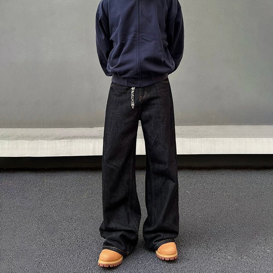 Close front view of black washed wide leg jeans featuring dark denim texture metal chain detail and relaxed fit