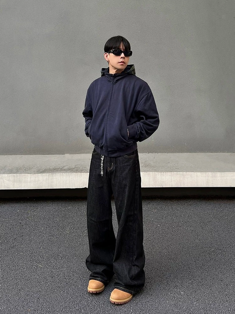 Front view of deep indigo wide leg streetwear jeans with chain waist accent and loose stacked leg fit