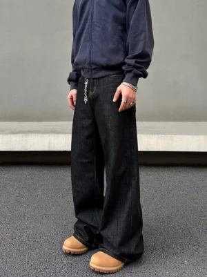 Three-quarter front side view of black washed wide leg denim jeans with relaxed streetwear fit