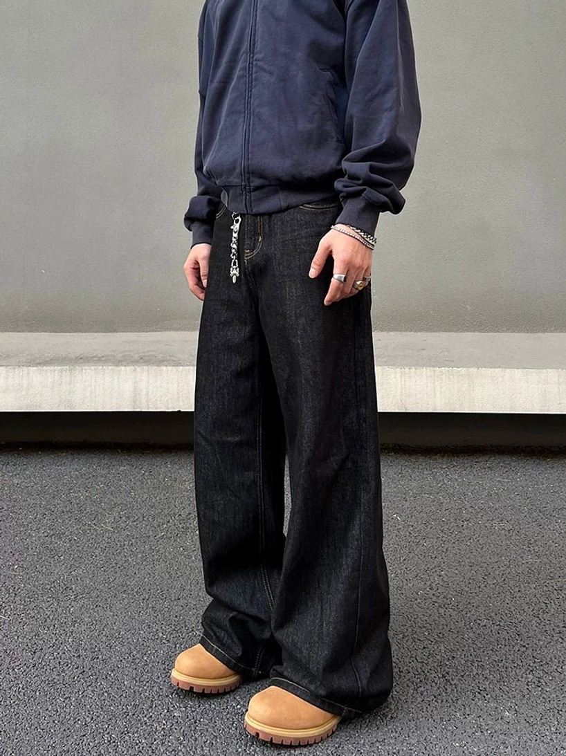Three-quarter front side view of black washed wide leg denim jeans with relaxed streetwear fit