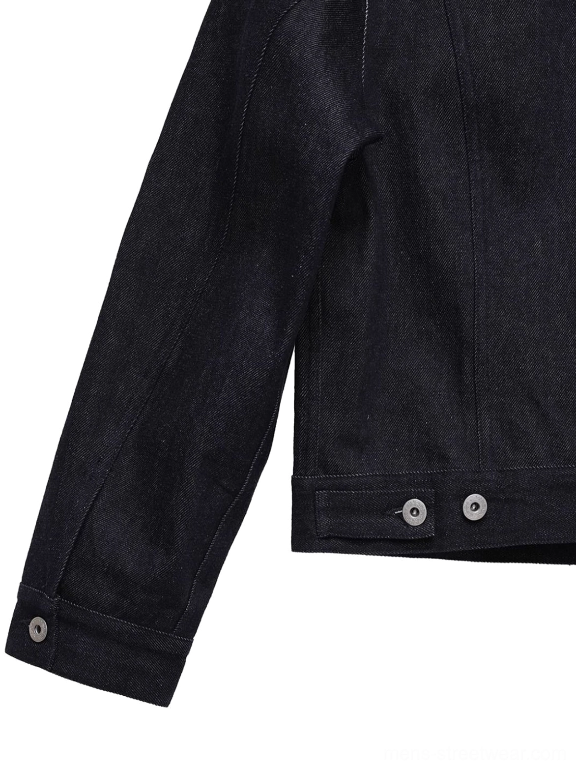 Close-up of button cuff and adjustable back hem tabs on dark indigo cropped denim trucker jacket