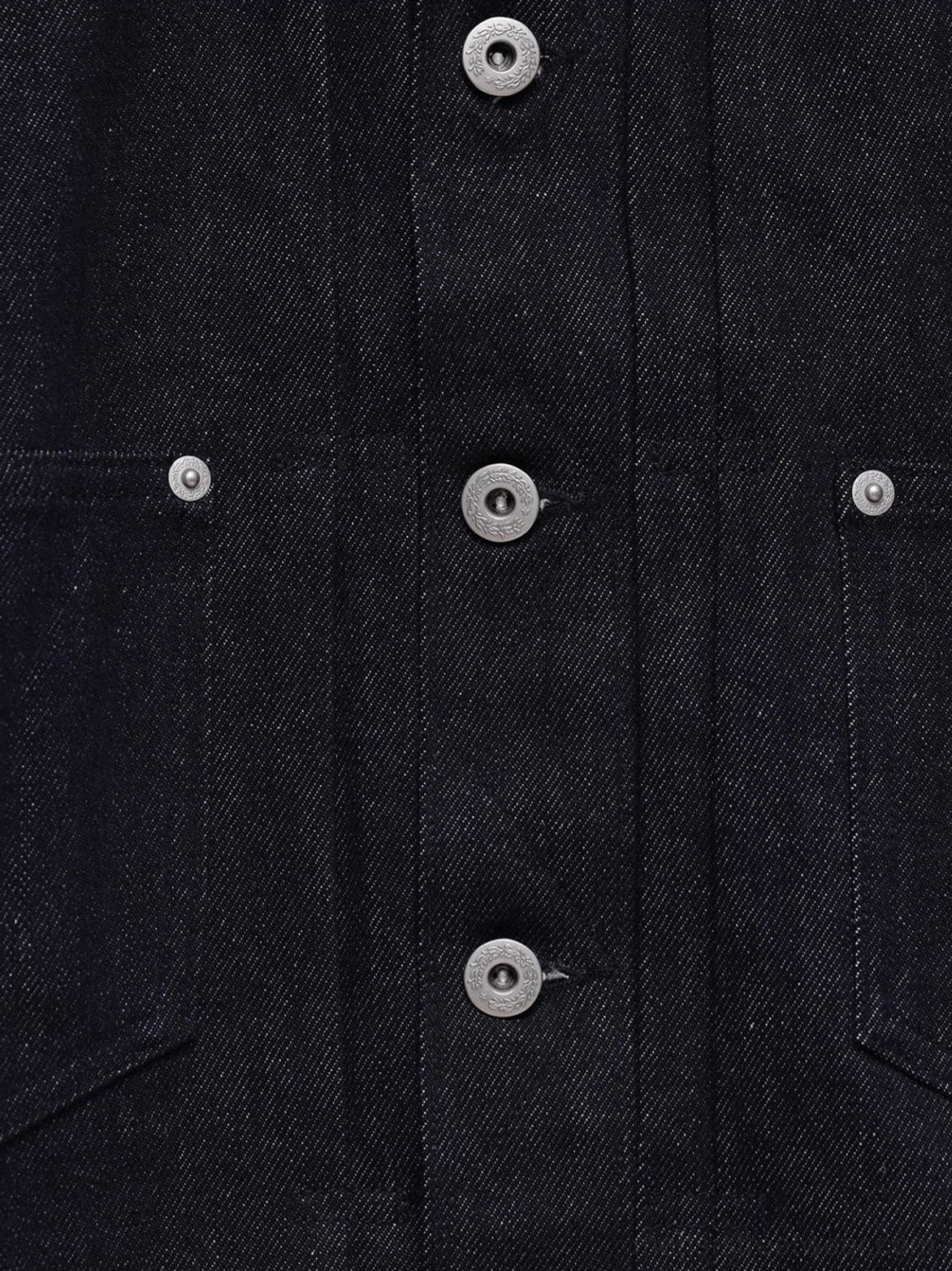 Close-up front placket and chest pocket detail on dark indigo non-fade cropped denim jacket