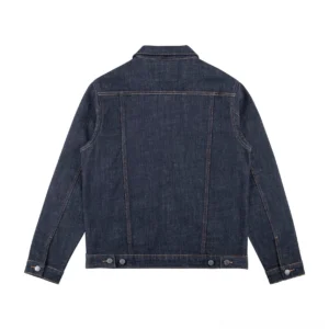 Back flat lay view of a dark blue denim trucker jacket showing the back yoke seam, adjustable side waist buttons, structured fit, and single-button sleeve cuffs