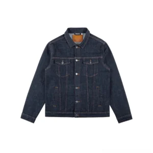 Front flat lay of a dark indigo denim trucker jacket with contrast tan stitching, metal button closure, classic point collar, twin flap chest pockets, and structured Korean streetwear silhouette