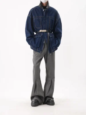 Dark indigo oversized denim utility jacket shown from the front with concealed zip closure, adjustable waist belt, high collar, and large workwear pockets