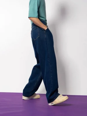 Rear three-quarter view of relaxed dark blue wide-leg jeans showing the back pocket and natural denim drape