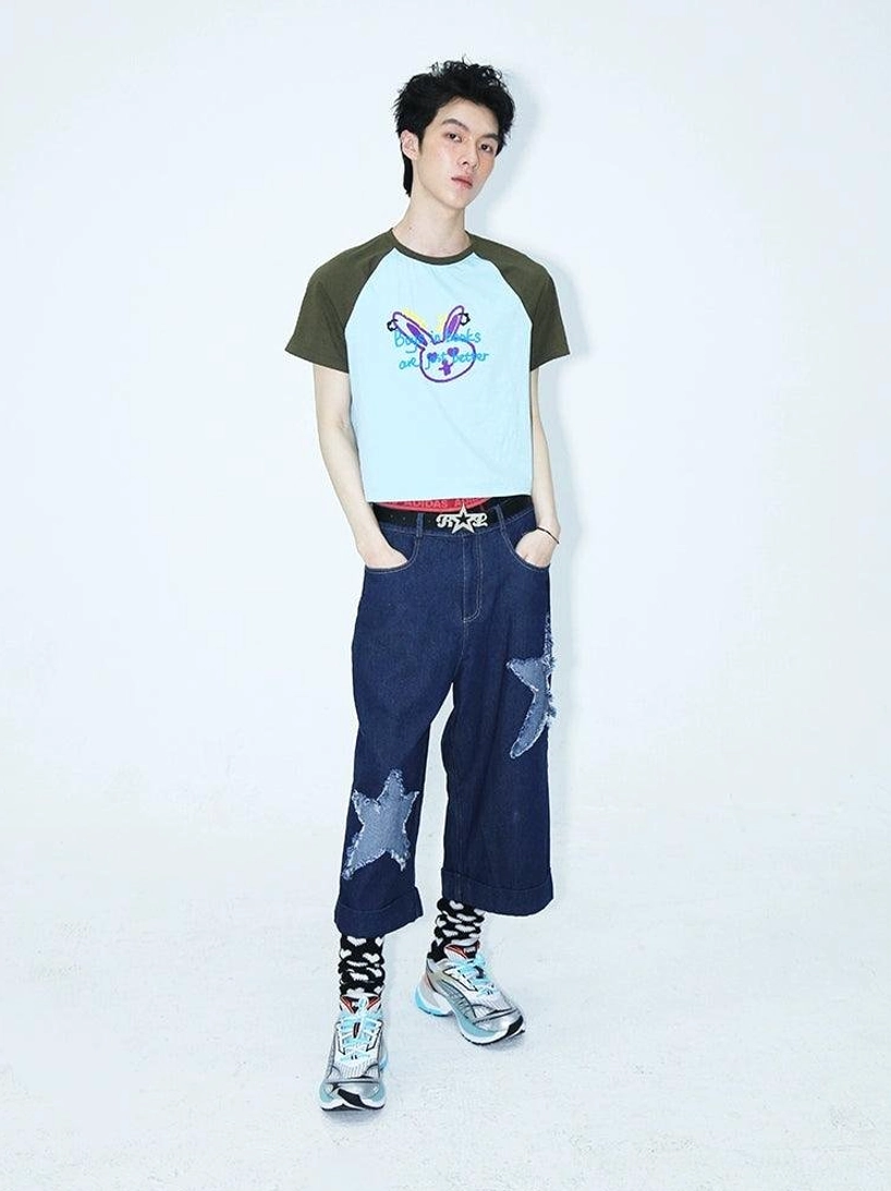 Front view of dark indigo cropped denim culottes with star patches, color block cropped top, patterned socks, and casual sneakers