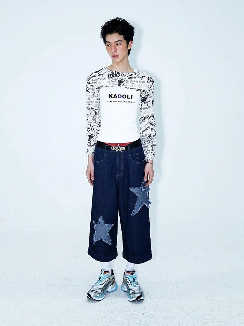 Full outfit styling of dark indigo star patch denim culottes with an all over print cropped long sleeve top and layered graphic tee