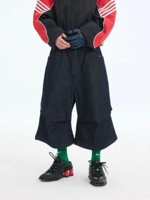 Front view of dark indigo wide-leg denim cargo capri shorts with layered hem and oversized Korean streetwear silhouette