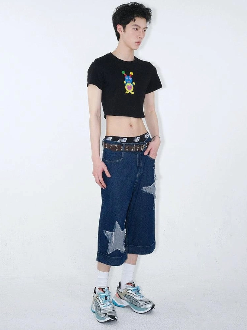 Three quarter view of dark indigo wide-leg denim culottes with frayed star appliqués styled in a relaxed Seoul streetwear outfit