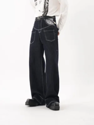 Side view of dark indigo wide leg utility jeans with white contrast stitching and oversized denim pockets