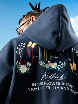 Dark navy floral embroidered zip-up hoodie close-up showing detailed back flowers butterfly accents bold lettering and decorative streetwear artwork