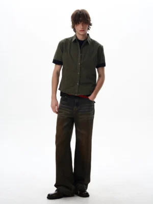 Dark olive green utility shirt with black contrast cuffs layered over a black tee for urban streetwear