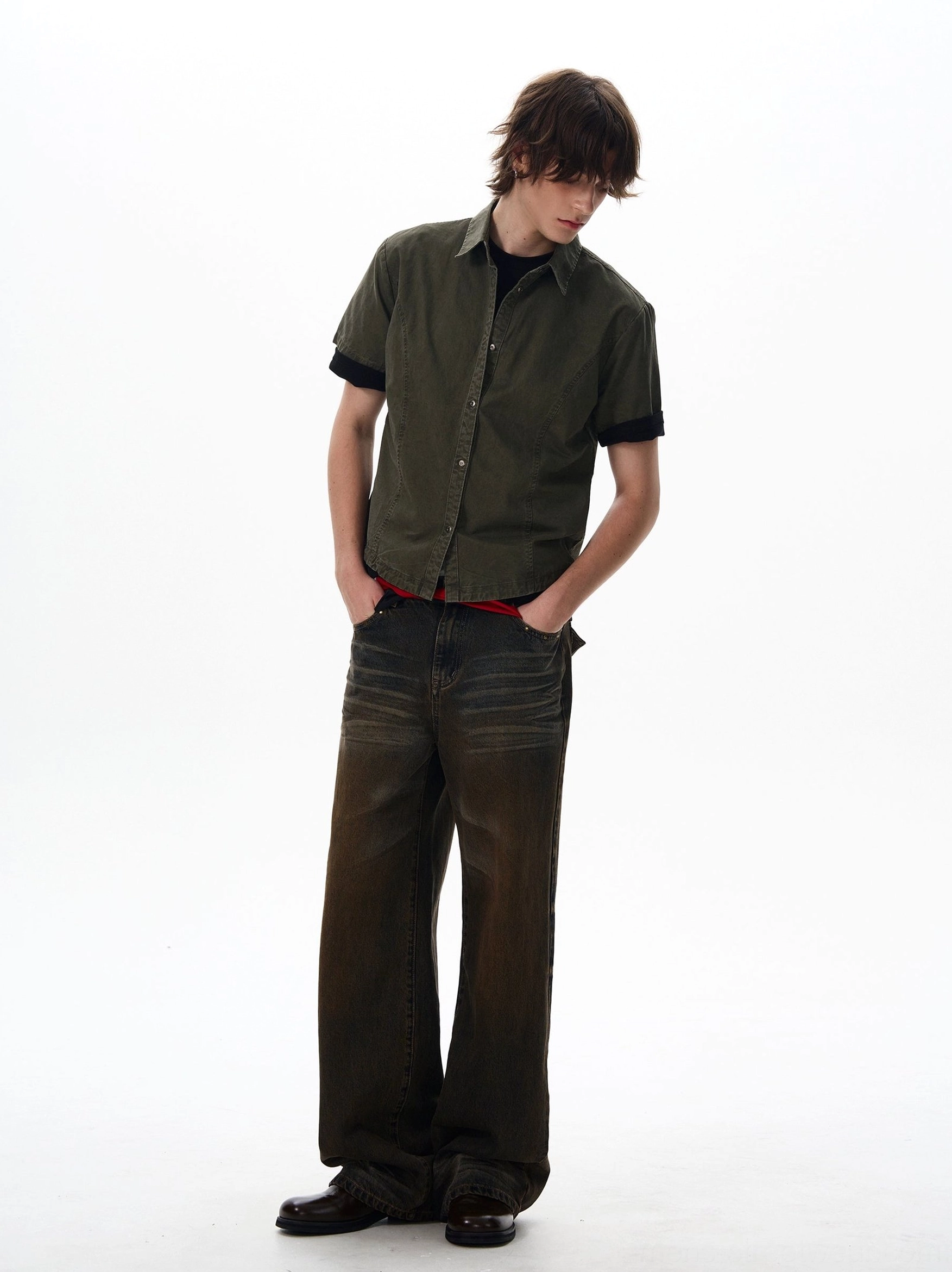 Rear three-quarter view of relaxed dark olive green short sleeve utility shirt with black cuffs