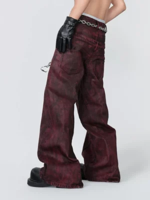 Rear three quarter view of dark red wide leg denim jeans showing back pockets, hanging chain detail, and relaxed grunge streetwear fit