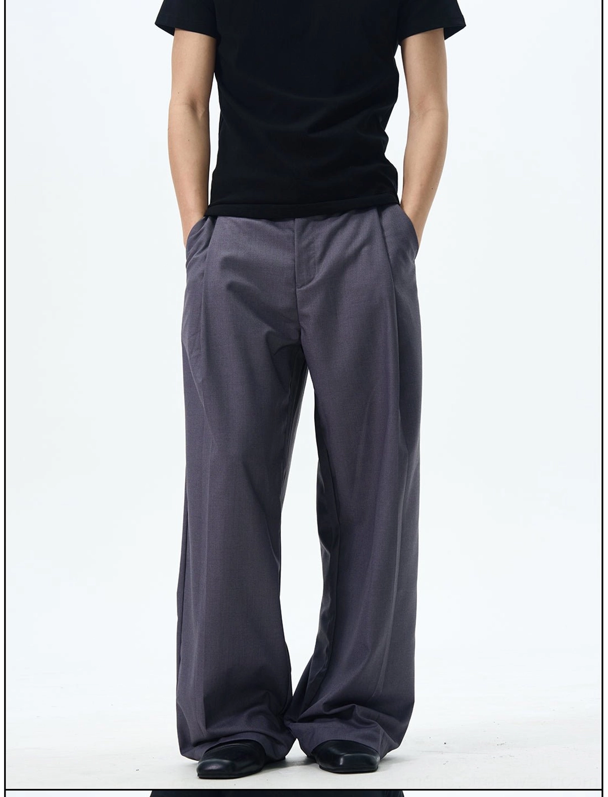 Front detail view of dark slate grey pleated wide leg tailored trousers with a clean straight silhouette