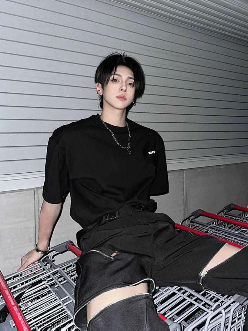 Black oversized streetwear t-shirt with tonal chest patch paired with utility shorts and layered necklaces