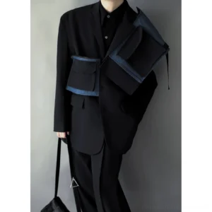 Men's deconstructed black cargo envelope blazer with indigo denim trim utility pockets worn in a front three-quarter streetwear outfit