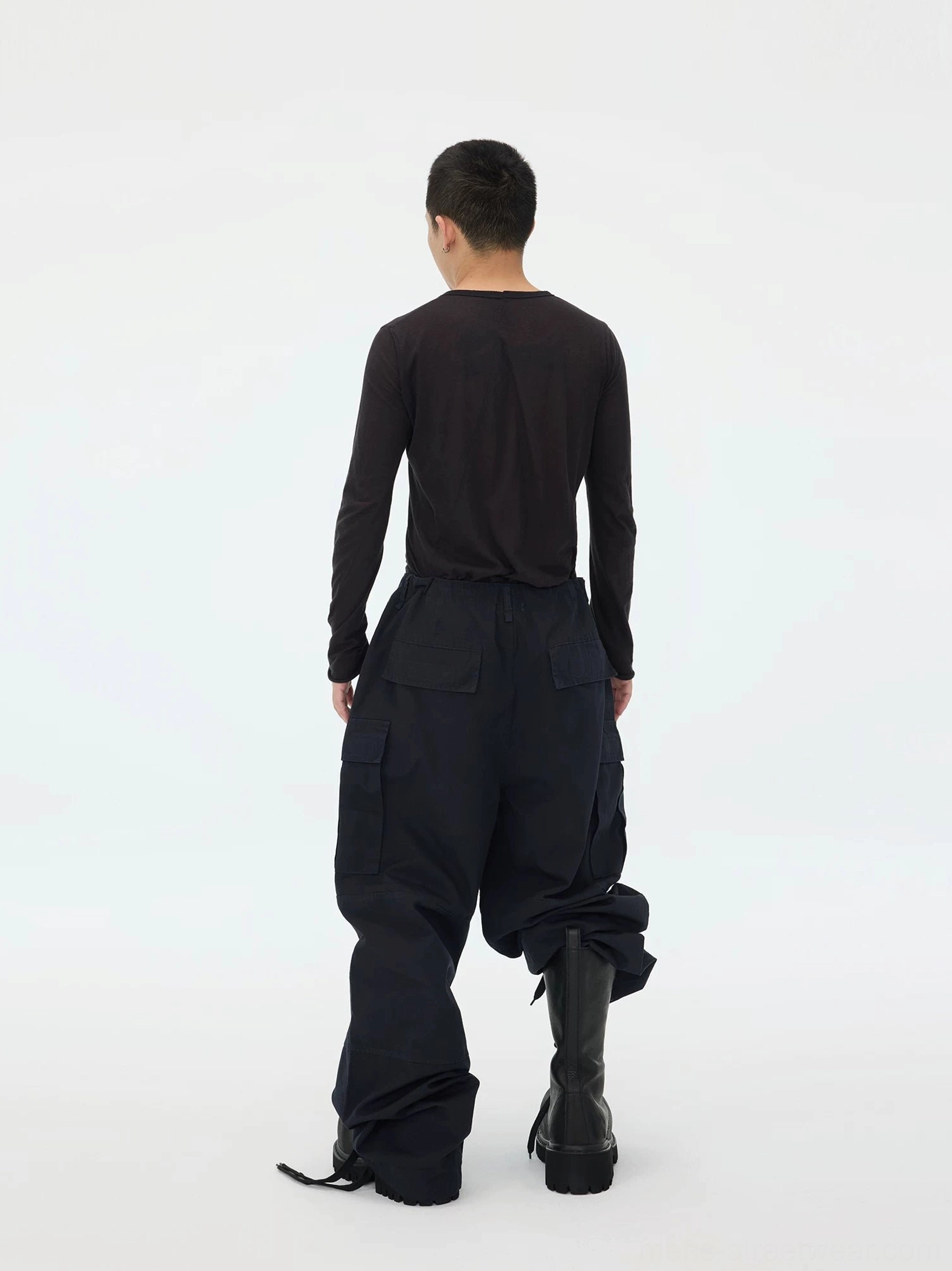 Back view of deep navy wide-leg cargo pants with rear patch pockets, stacked hem styling, ankle drawstrings, and oversized streetwear silhouette