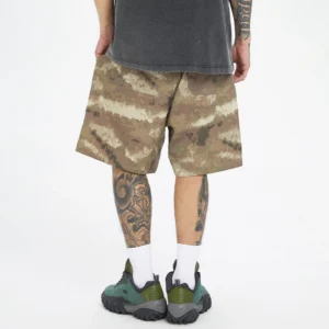 Close front view of relaxed fit desert digital camouflage cargo shorts with dark green outdoor sneakers