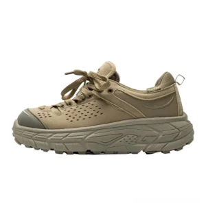 Desert yellow chunky trail sneakers with perforated synthetic leather upper, lace-up front, protective toe guard, and deep lug rubber outsole shown from the left side