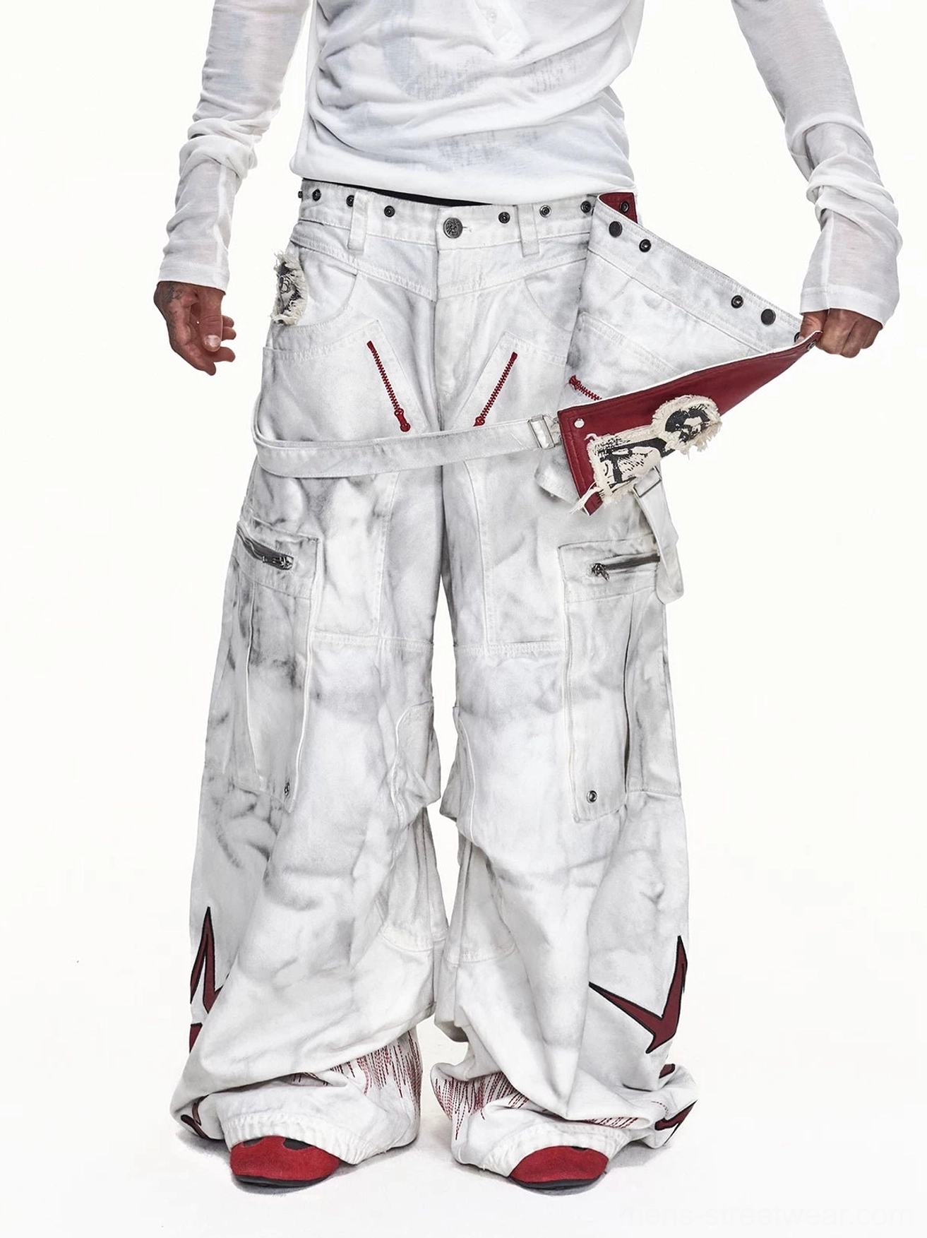 Front low-angle model view of washed off-white detachable red apron wide-leg cargo pants with oversized utility pockets and red star graphics