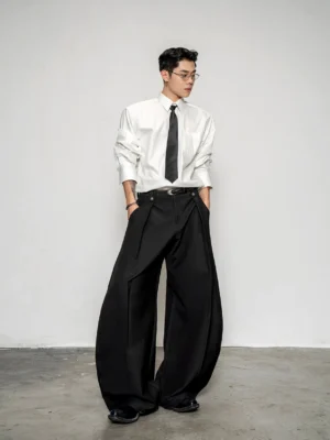 Men's oversized white cotton shirt styled with a black tie and wide-leg pleated trousers in a minimalist smart casual streetwear outfit