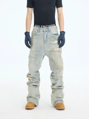 Front full-body view of dirty blue distressed acid wash stacked flare jeans with ripped knees and wide flared legs