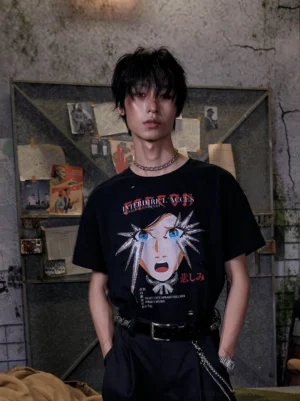 Front view of distressed black anime girl graphic streetwear t-shirt worn by male model in industrial grunge room