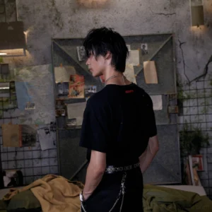 Side back view of black distressed anime graphic streetwear t-shirt with plain back panel and raw hem