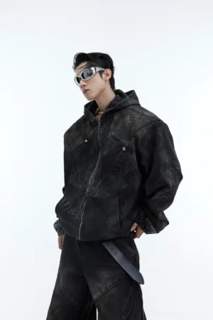 Front view of an oversized distressed black hooded denim jacket with structured padded shoulders, metal zipper, acid wash finish, and avant garde Seoul streetwear styling