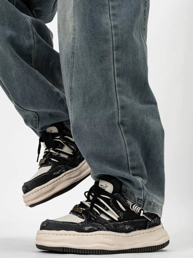 Black and white distressed canvas platform skate sneakers with layered laces worn with baggy denim