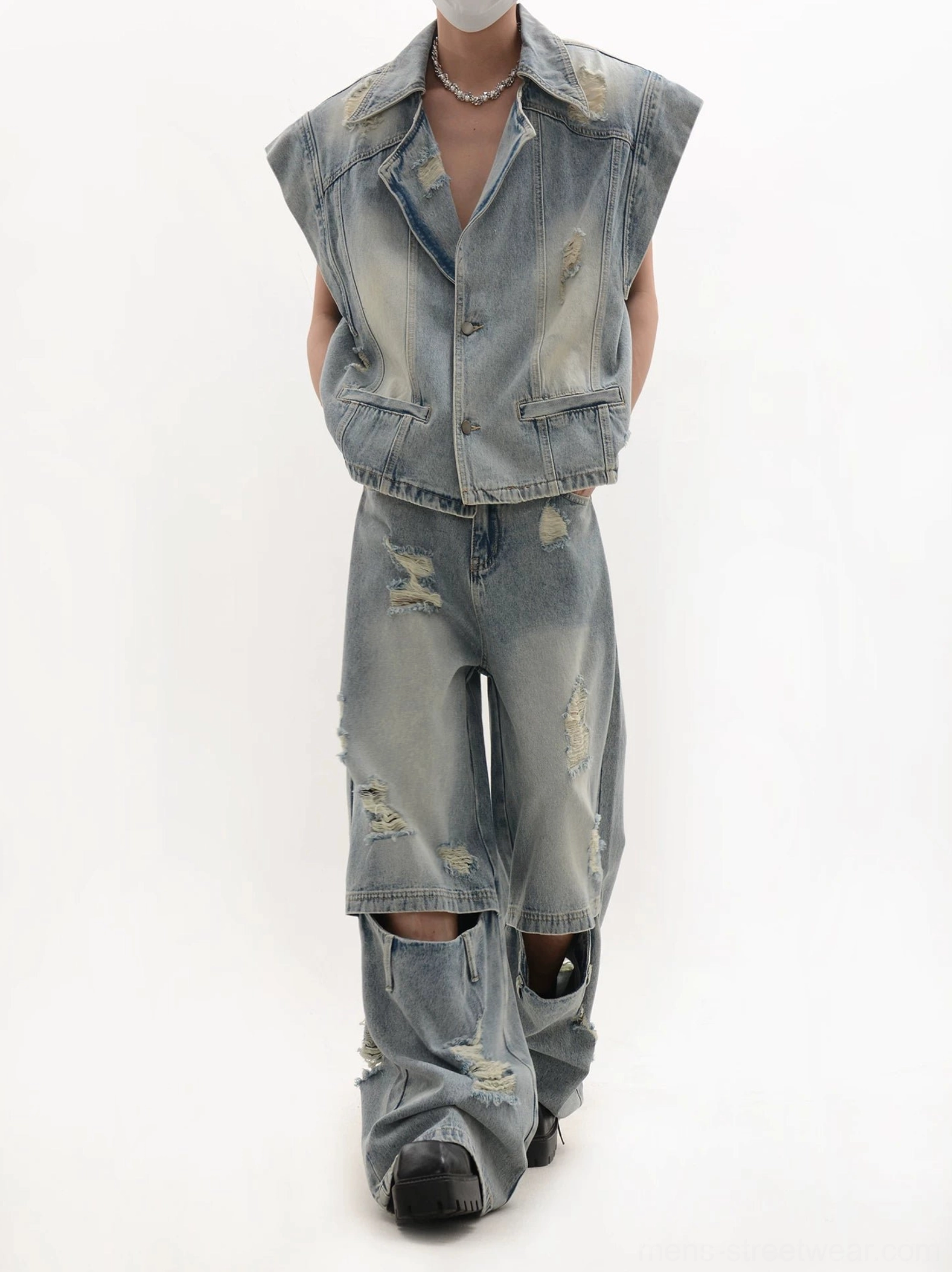 Three-quarter view of a distressed oversized denim vest with matching jeans featuring knee cut-outs and wide legs