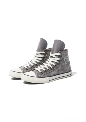 Front three-quarter view of distressed gray denim high-top canvas sneakers with white rubber toe caps, elongated laces, and circular side badges