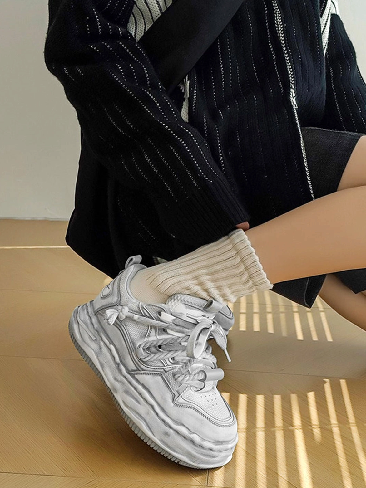 Distressed gray platform sneakers highlighting the layered lace-up upper and bold sculpted sole for Korean fashion styling