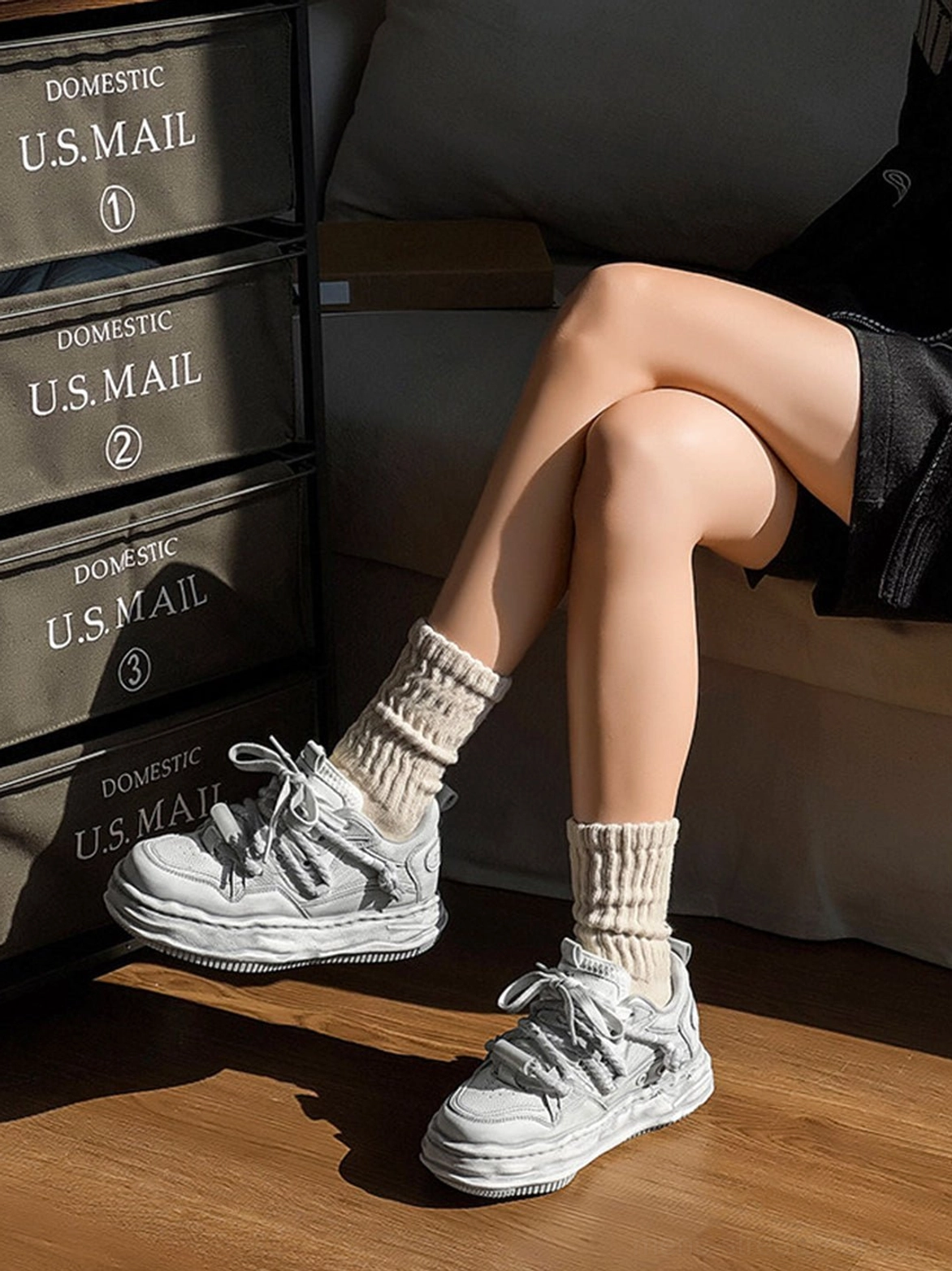 Distressed gray platform sneakers shown from a low side angle with beige socks and black shorts in natural light