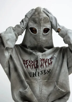 Front view of a faded grey distressed graphic zip hoodie with masked hood, red streetwear prints, front pockets, and matching grey glove styling