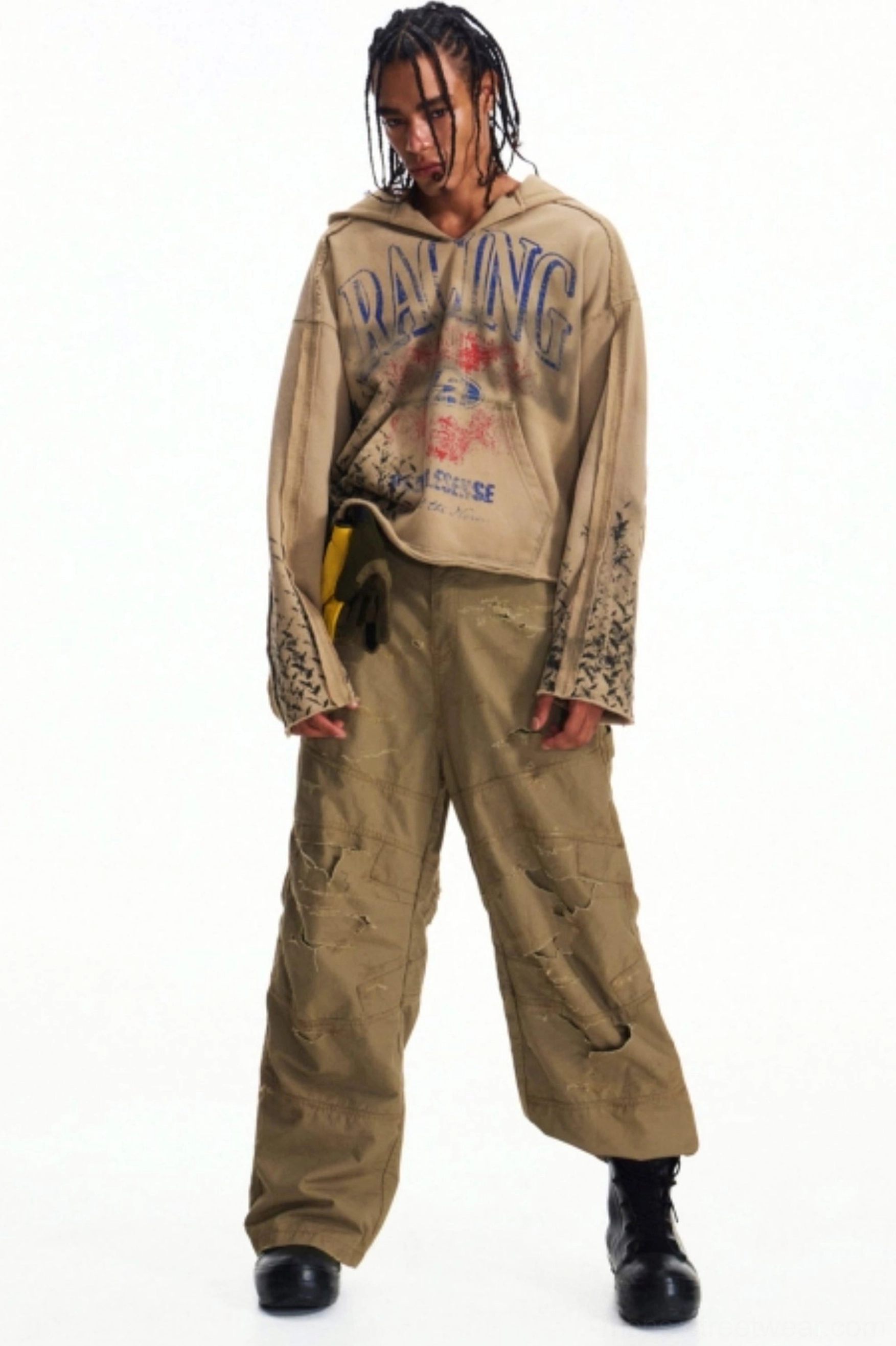 Three-quarter full-body view of a model wearing khaki wide-leg cargo pants with vintage graphic hoodie and black work boots
