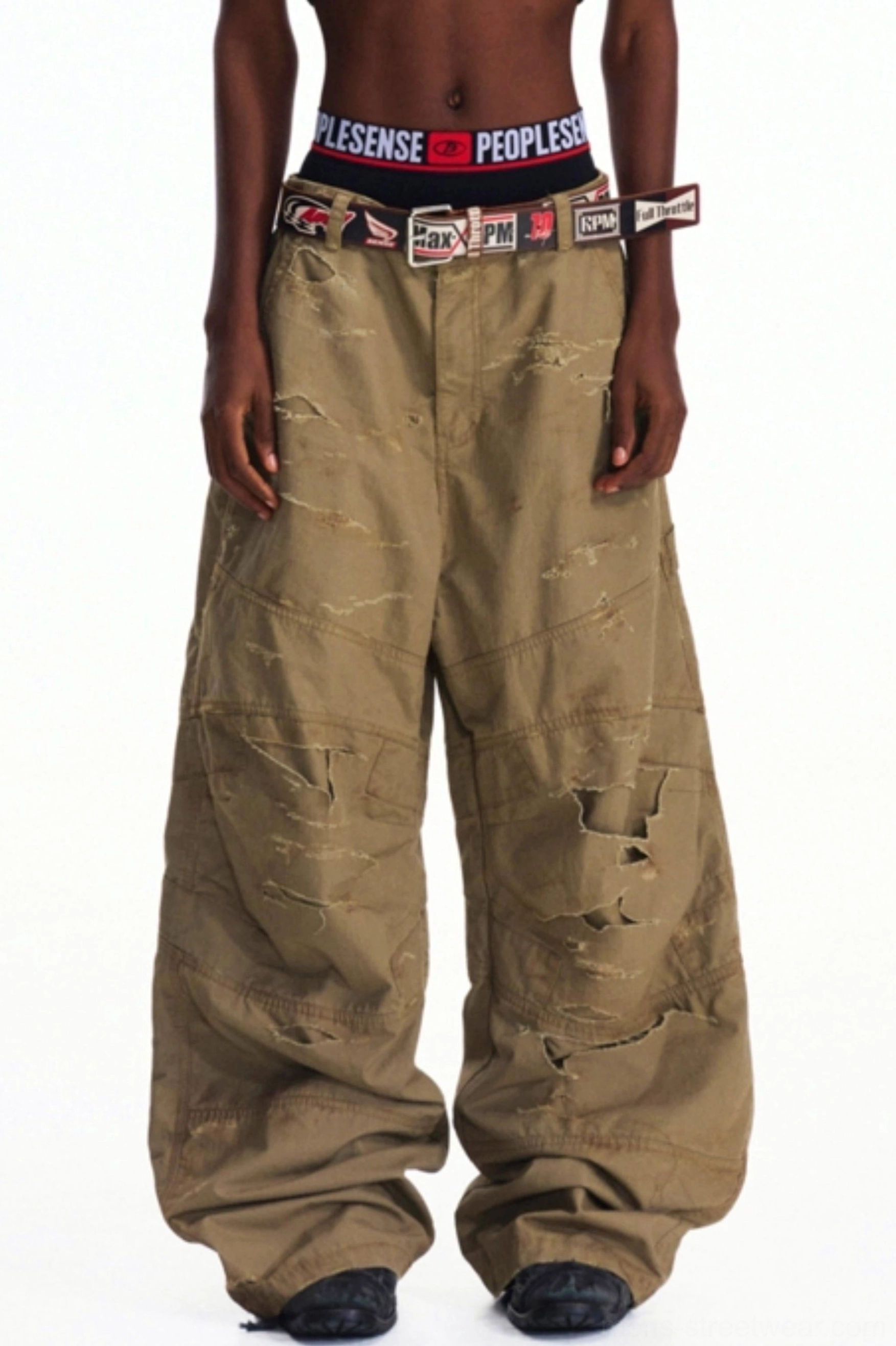 Right three-quarter view of khaki distressed cargo pants featuring large side utility pockets, raw frayed details, and baggy streetwear fit