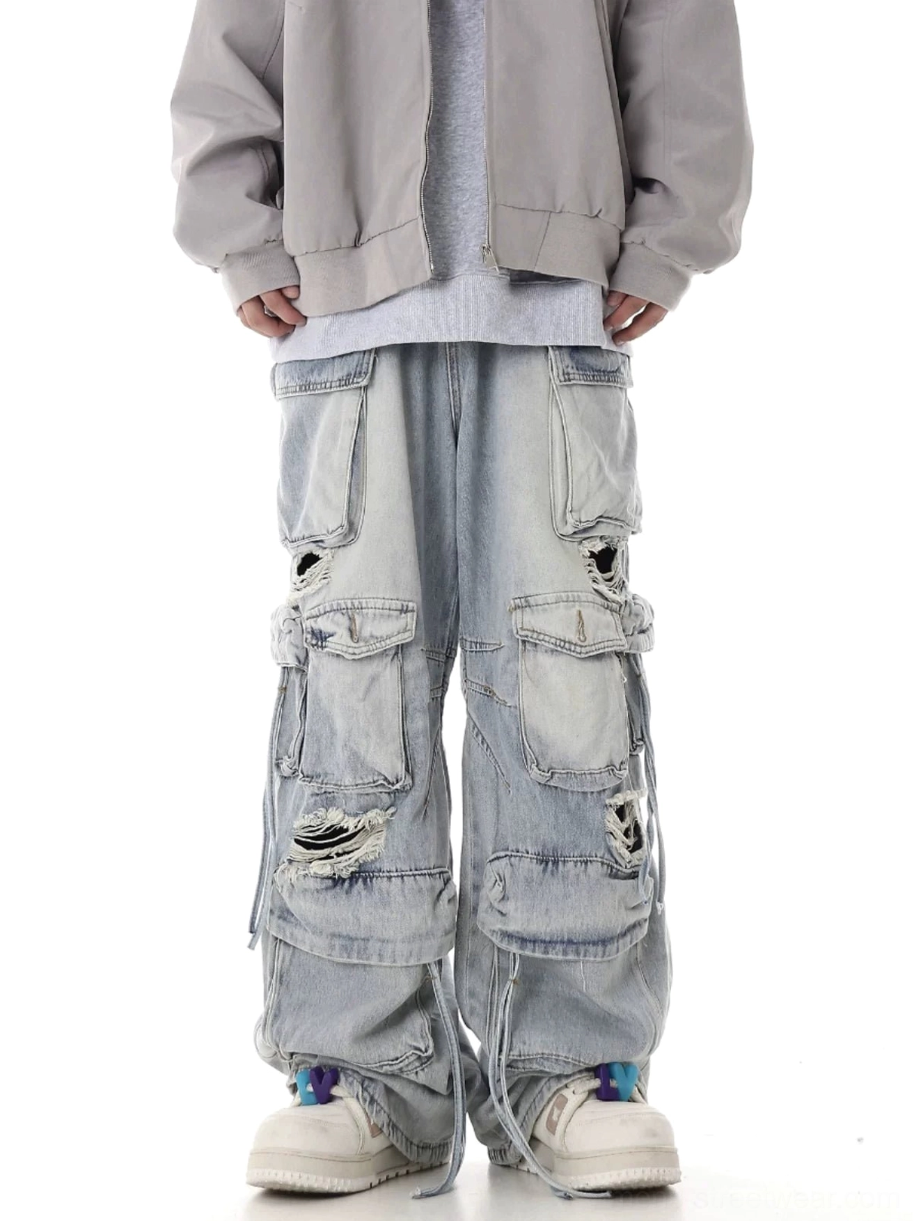 Light blue distressed multi-pocket wide-leg cargo jeans with ripped denim panels and drawstring hems front view