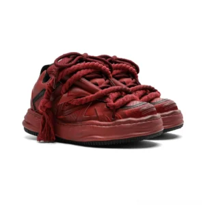 Wine red distressed rope-lace chunky sneakers with oversized braided laces, frayed tassel ends, layered geometric panels, and a thick weathered platform sole