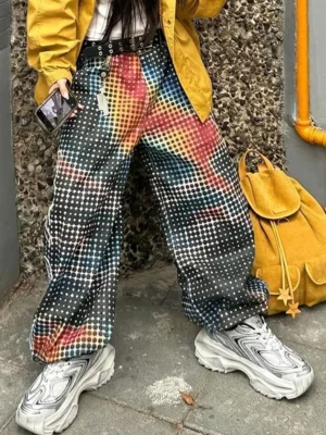 Female streetwear outfit wearing distressed silver dad sneakers with yellow jacket and gradient checkered wide-leg pants on an urban street