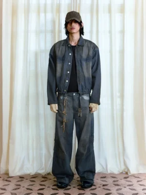 Male model wearing dark distressed stacked wide-leg jeans with matching denim jacket in Seoul streetwear outfit