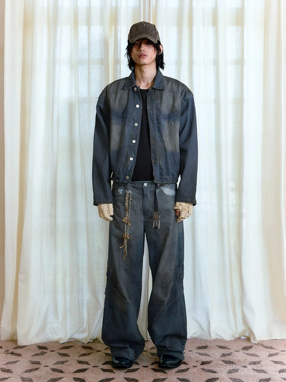Male model wearing dark distressed stacked wide-leg jeans with matching denim jacket in Seoul streetwear outfit