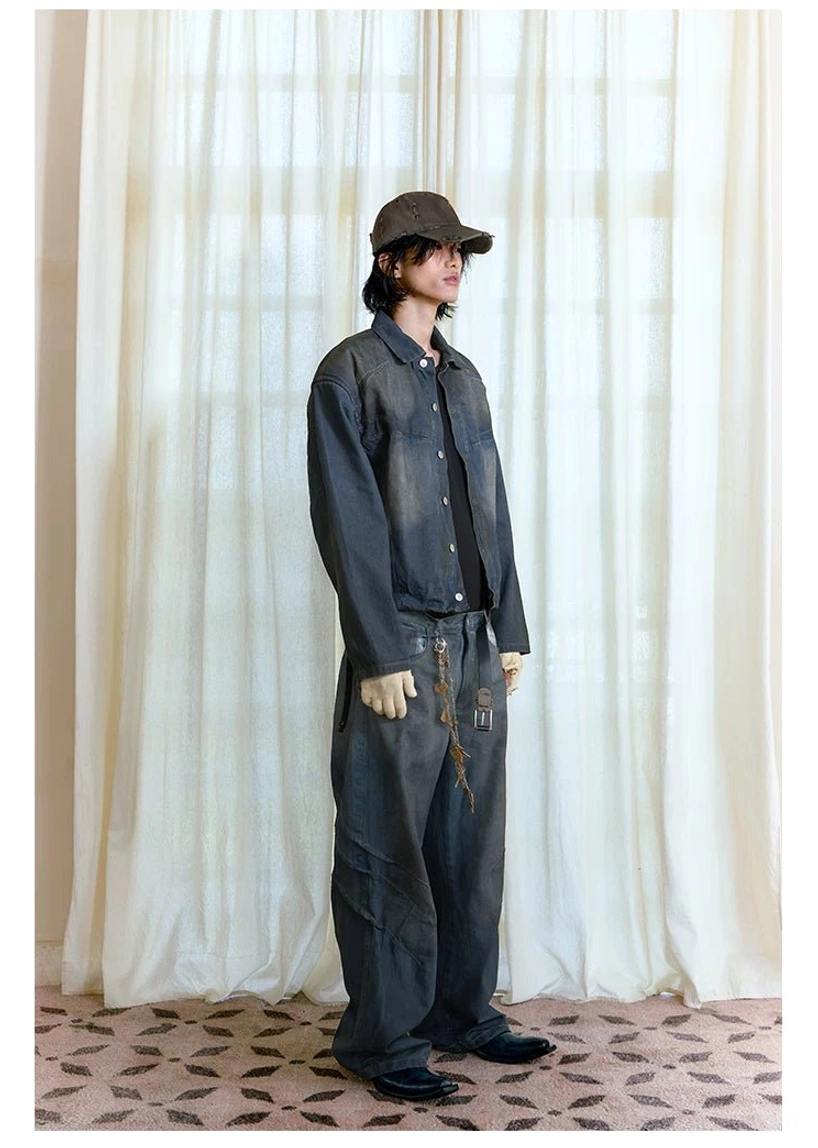 Side profile of male model in distressed denim streetwear outfit featuring stacked wide-leg jeans