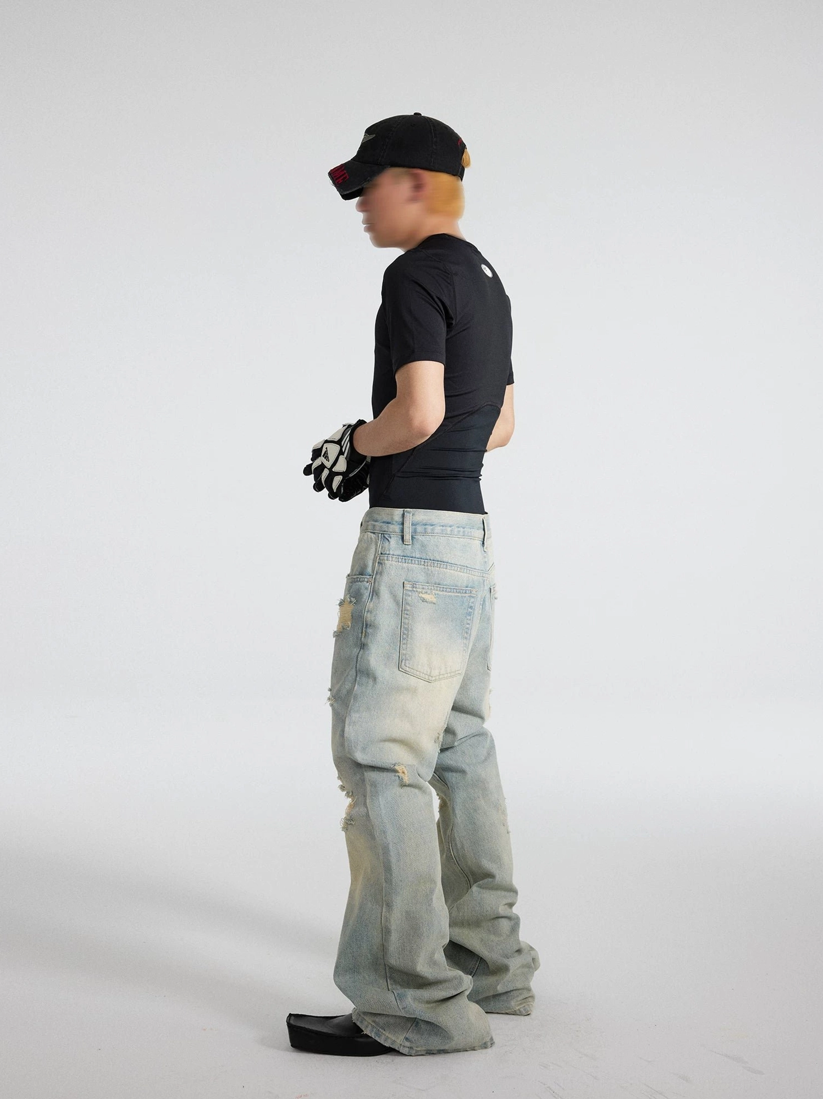 Men's light blue distressed sunfade flare jeans in left side studio view, showing the washed denim texture, worn side seam detailing, loose leg fit, and retro wide flared silhouette
